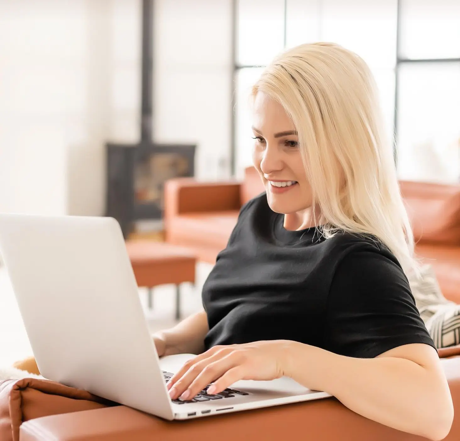 A business owner working on her laptop, smiling