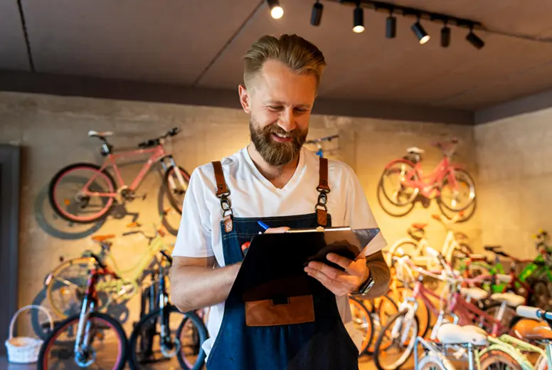 A bike shop owner checking orders on a tablet